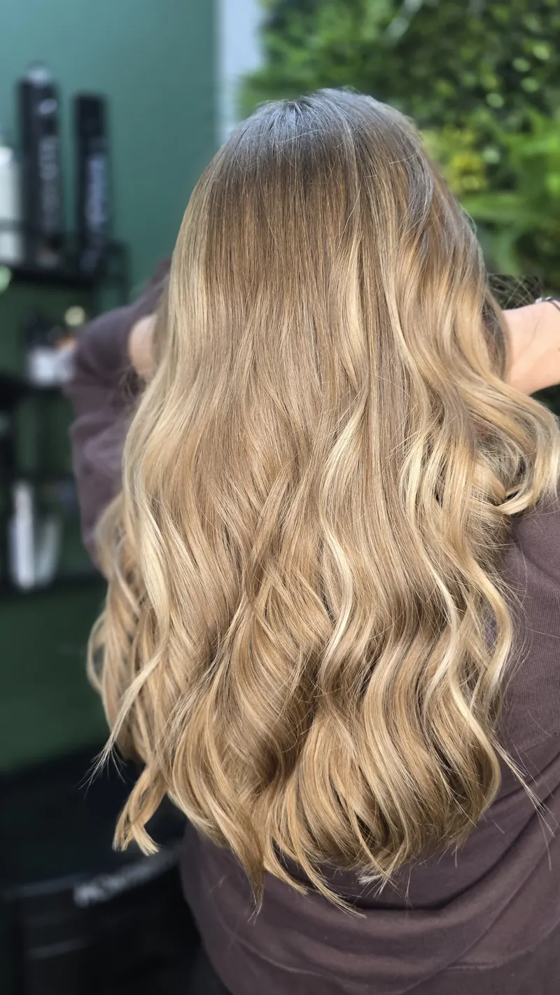 Long waves in warm beige blonde with balayage and a root shadow — hair by Jowita Litwin, Goleniów