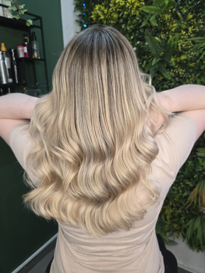 A side view of the same long beige waves with darker roots — hair by Jowita Litwin, Goleniów
